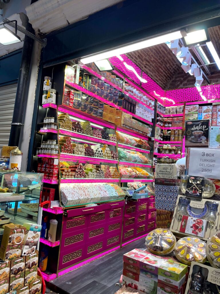 A small shop in the Egyptian Spice Bazaar with bright pink shelves full of different types of Turkish delight.