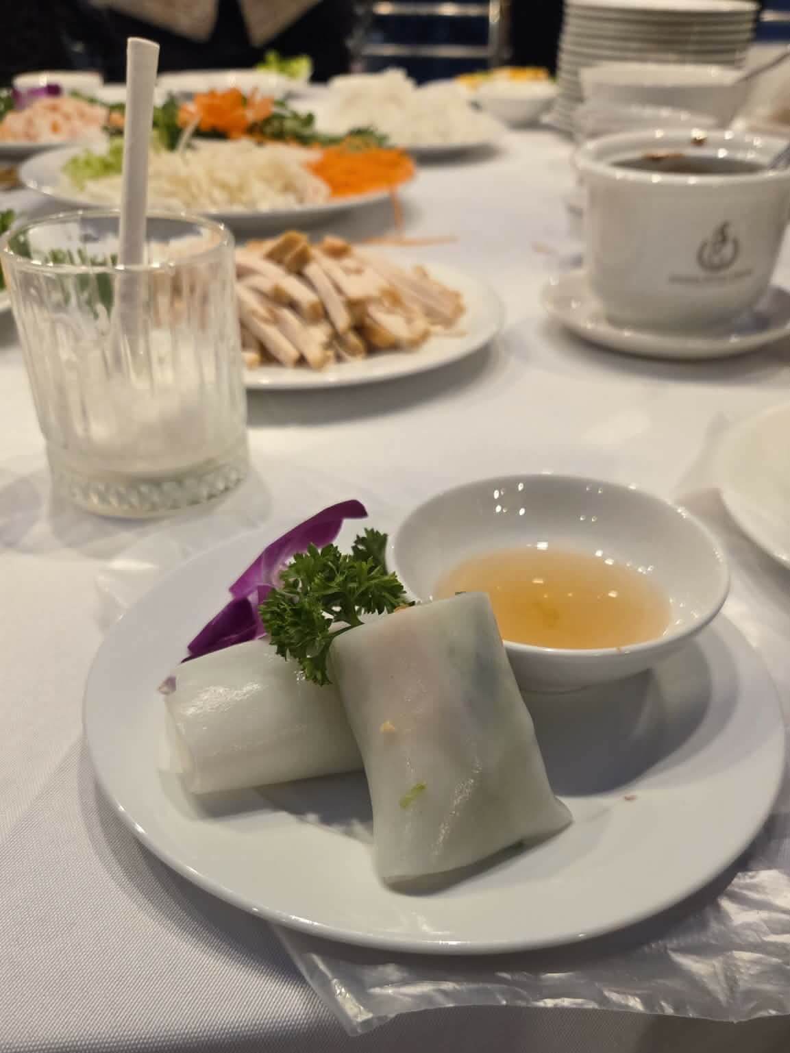 Vietnamese rice paper rolls made during the cooking class with the ingredients in the background