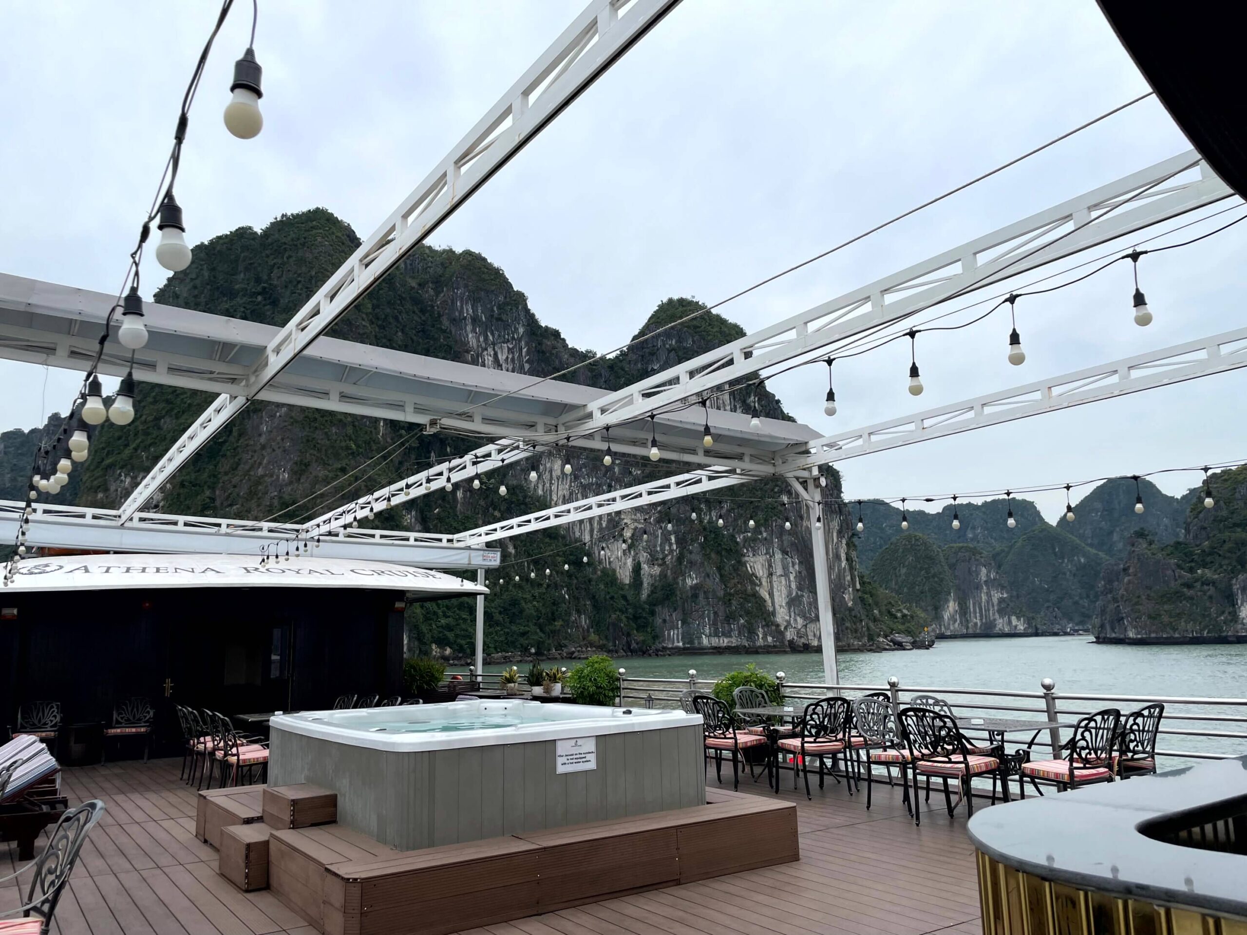 The sundeck of Athena Royal Cruise with Halong Bay's limestone karsts in the background