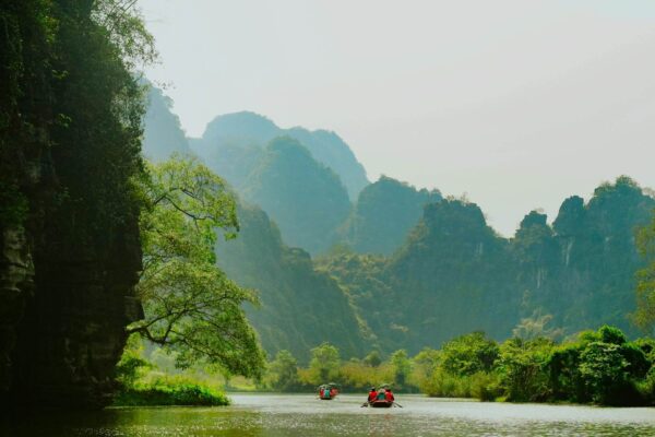 Two boats floating down a scenic river in Ninh Binh, Vietnam
