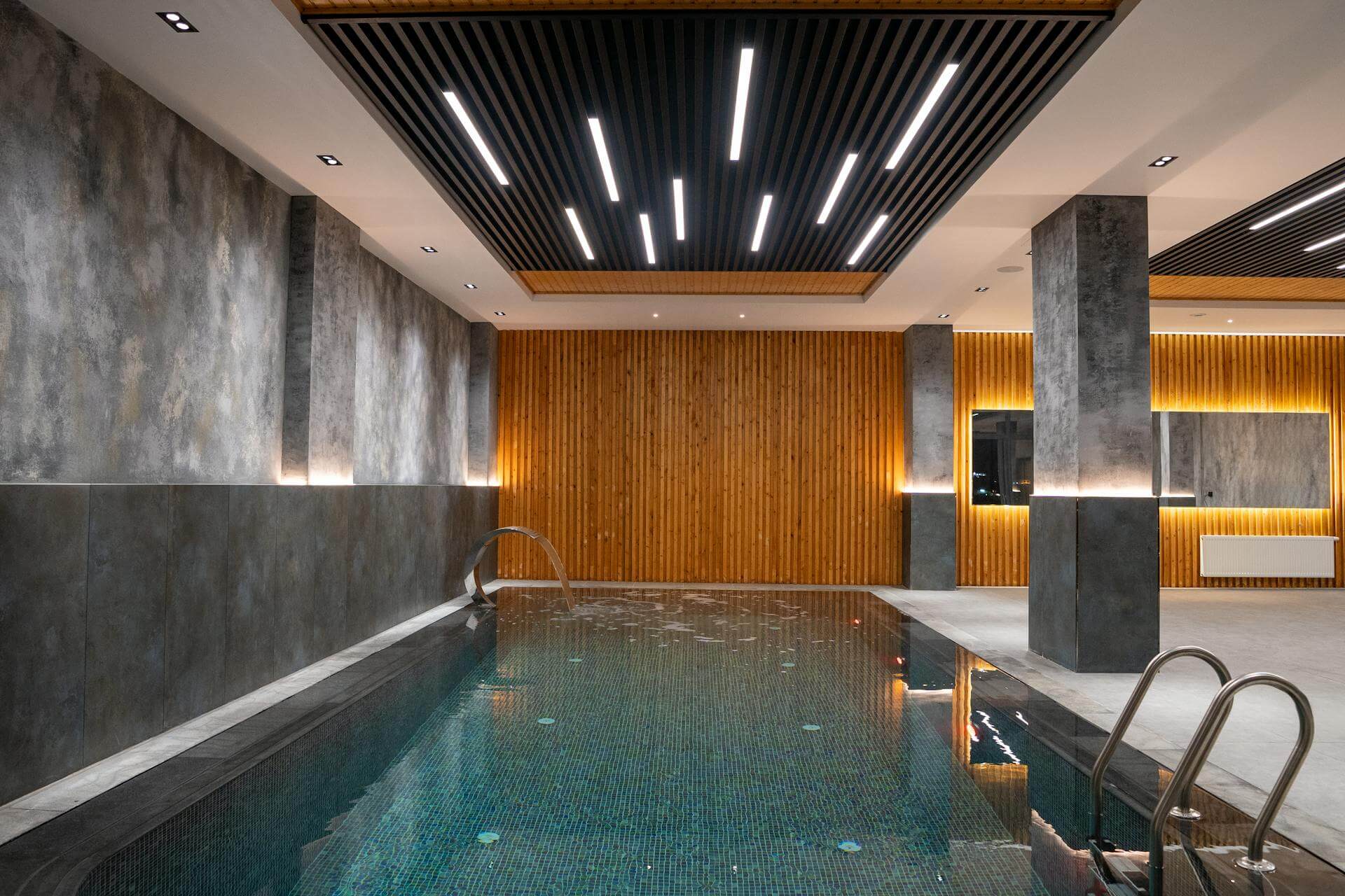 Indoor bathhouse mineral pool with tiled walls and soft lighting creating a calm and relaxing spa atmosphere.