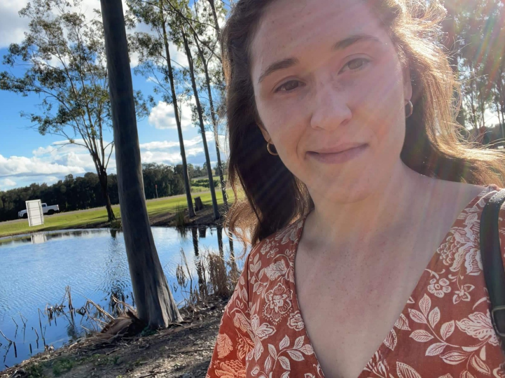 Rebecca taking a selfie beside a pond surrounded by trees and open countryside in the Hunter Valley.