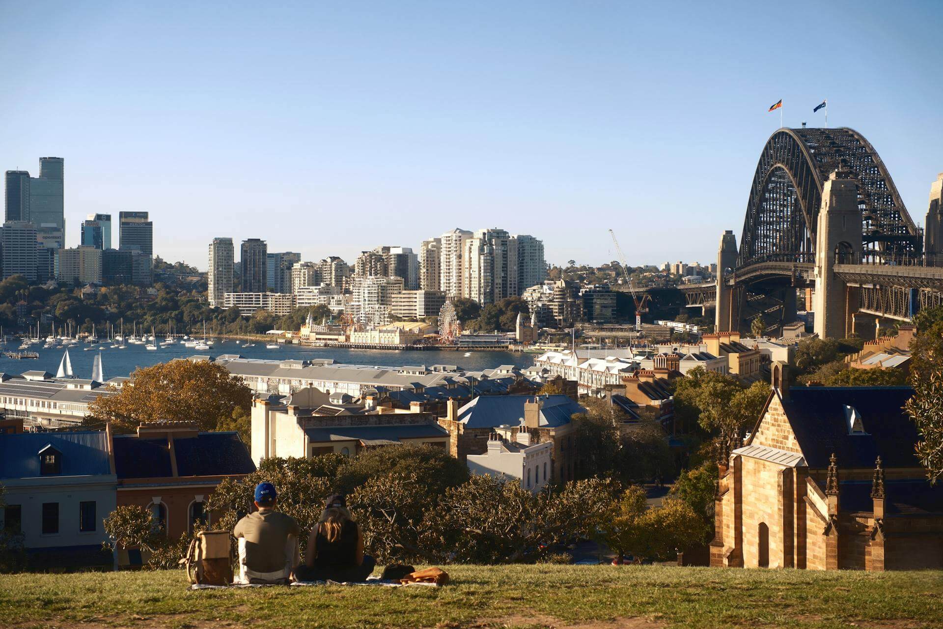 The view across Sydney Harbour toward the city skyline and Harbour Bridge from Observatory Hill.