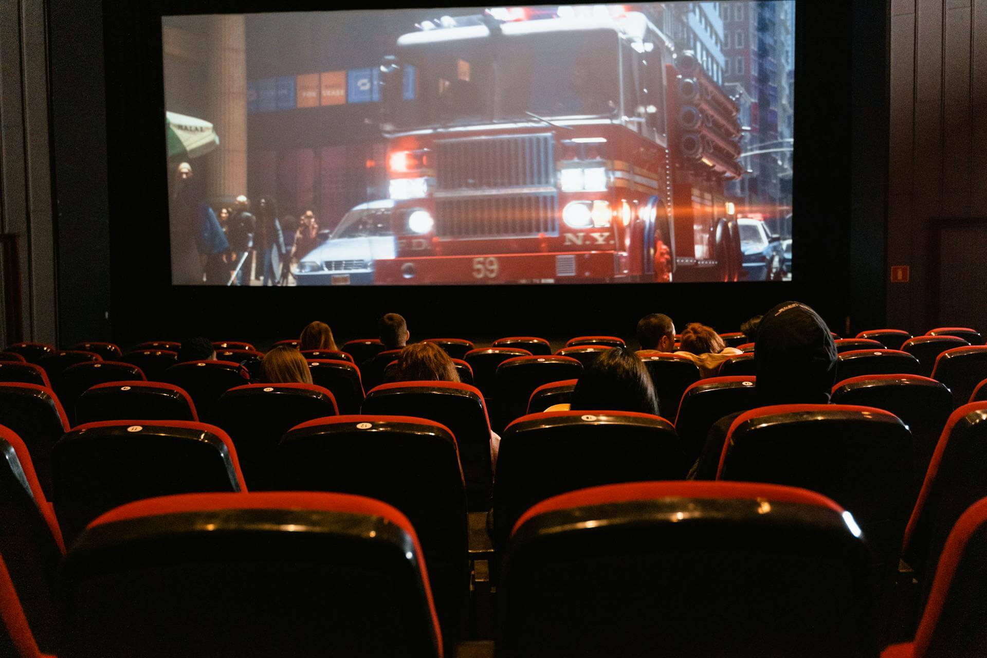 Rows of red cinema seats facing a large movie screen during a Sydney Film Festival screening.