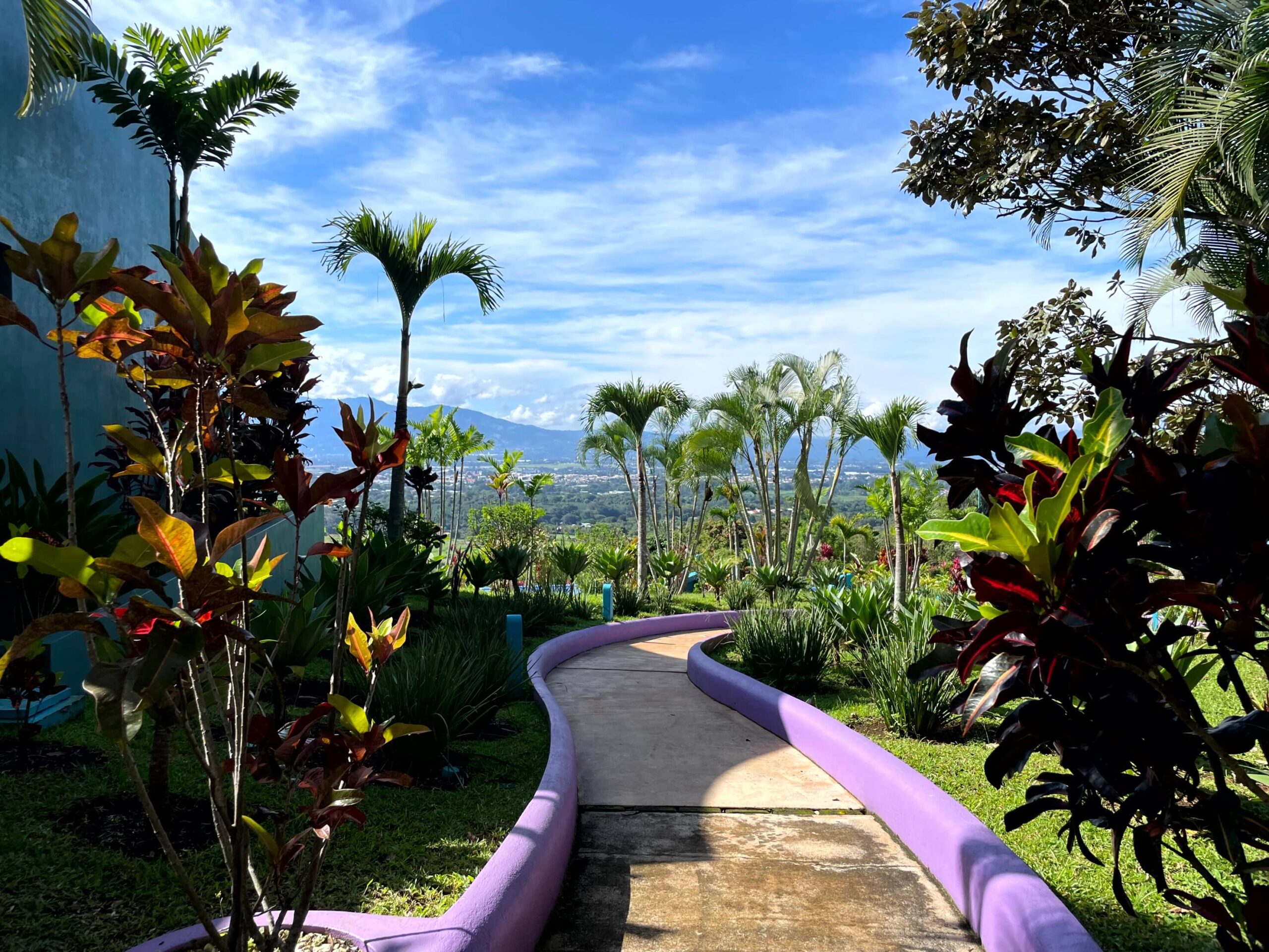 A footpath through the gardens of Xandari Resort with views of the valley in the distance.